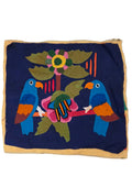 Colorful fabric with floral and bird design on a tiled floor